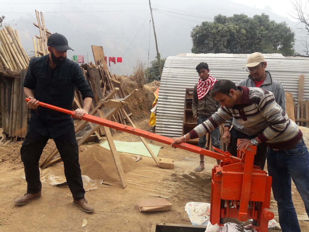 Booni Box founder Anuj helping man from impact project to operate a red winch machine