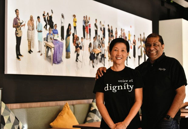 Man and woman wearing black t shirts with Voice of Dignity printed on them